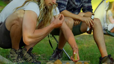 friends lighting campfire in the forest 4k