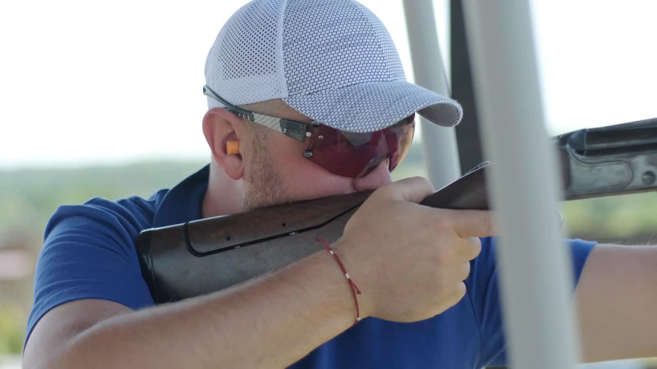 un deportista dispara con una escopeta de doble cañón, un campo deportivo para una prueba de tiro está disparando a un esquete volador