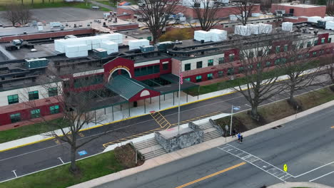 group of people walk by american school in usa