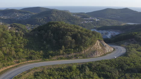 Ascenso-Lento-Sobre-El-Camino-Serpenteante-Con-Edificios-De-Pequeñas-Ciudades-En-Las-áreas-Boscosas-En-El-Fondo,-En-La-Puesta-De-Sol,-Rusia,-Lejano-Oriente