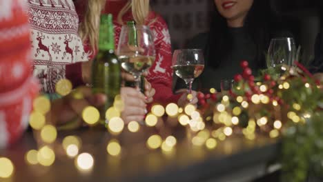 Captura-De-Seguimiento-De-Amigos-Sentados-En-Un-Bar-Con-Bebidas-Durante-Las-Celebraciones-Navideñas