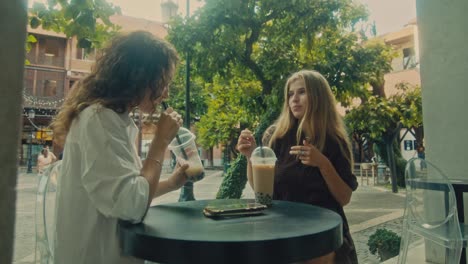 two friends enjoying bubble tea at an outdoor cafe