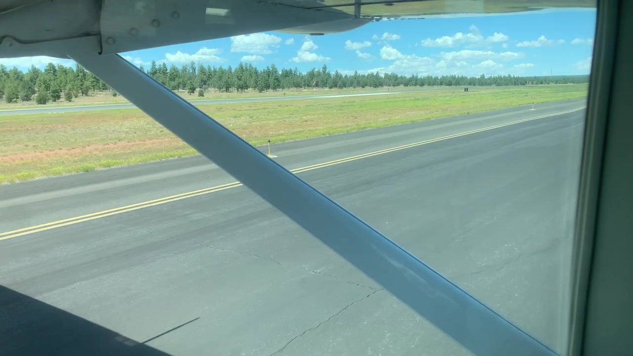 Hjul på ett litet flygplan när det taxar nerför en landningsbana på en liten privat flygplats en solig klar dag
