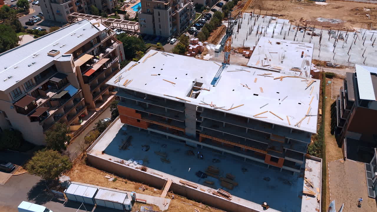 Urban construction of a modern residential building. Aerial drone view of a residential building under construction in a developed neighborhood