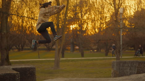 man jumping in park at sunset