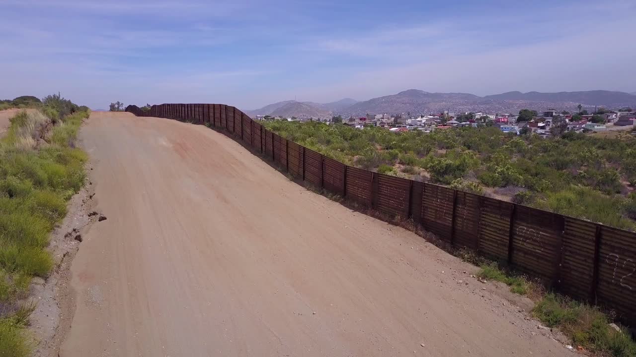 antena de lento ascenso a lo largo de la cerca del muro fronterizo con méxico revela la ciudad de tecate méxico