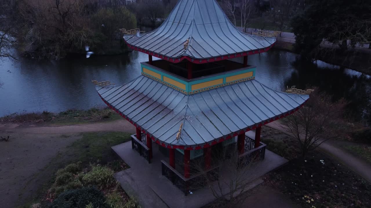 Cảnh quay trên không ở độ cao thấp về một ngôi chùa và ao trong công viên Đông Luân Đôn. Được quay vào sáng sớm với cảnh quay theo dõi lên cao của Chùa Victoria Park