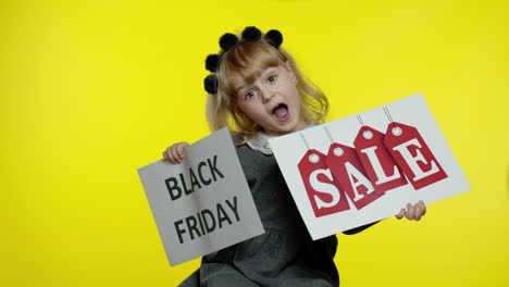 cheerful blonde child girl showing black friday and sale word advertisement inscriptions banners