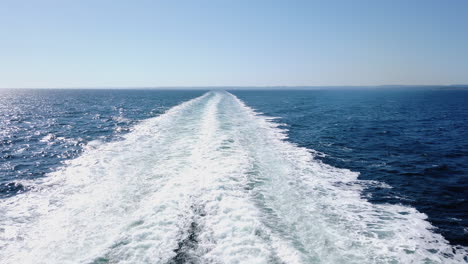 pov shot backwards of waves coming from a moving car ferry, on the skagerrak ocean, heading towards denmark, from south norway, on a sunny summer day