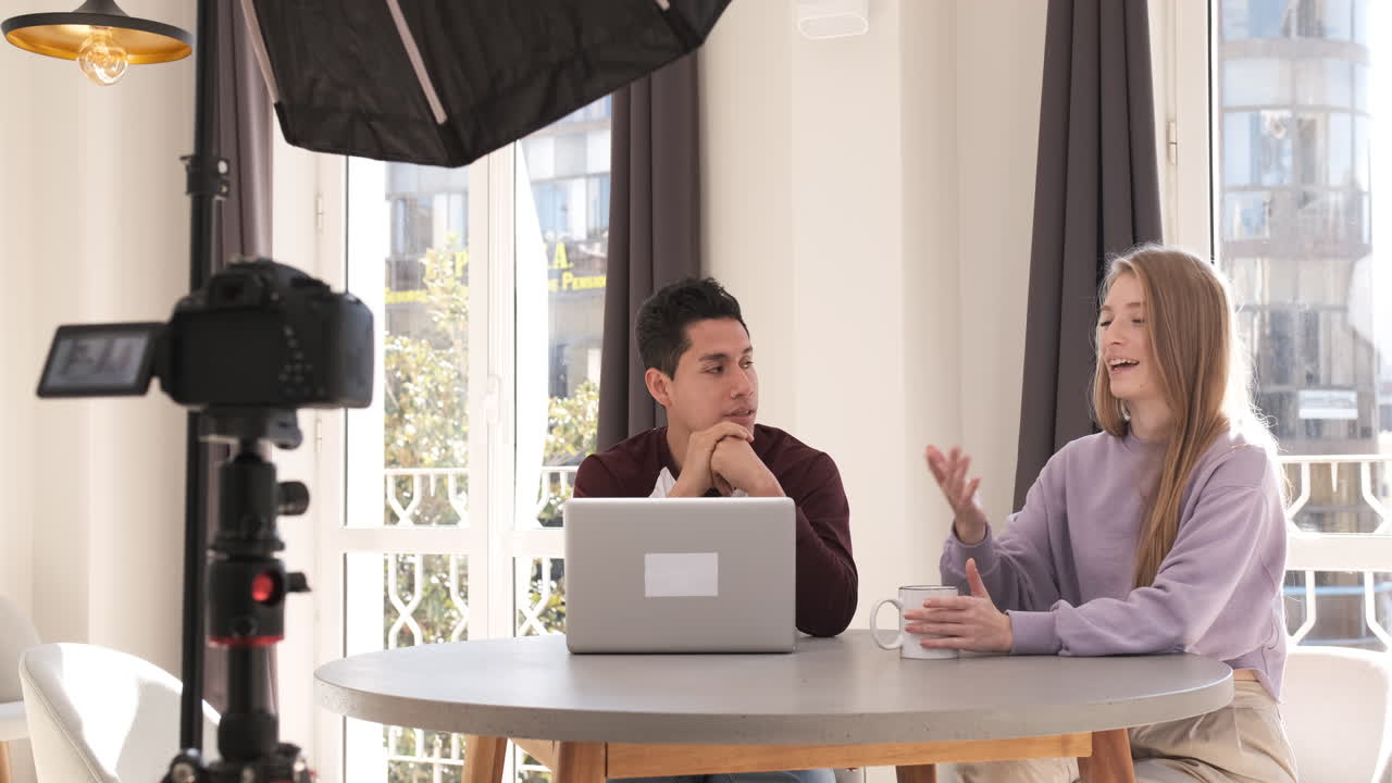 bloggers de video haciendo un video con una cámara profesional en un trípode en casa.