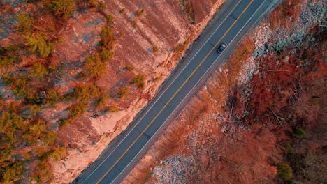 aerial drone top down video footage of a beautiful mountain highway during fall autumn in the appalachian mountains, with golden light at sunset