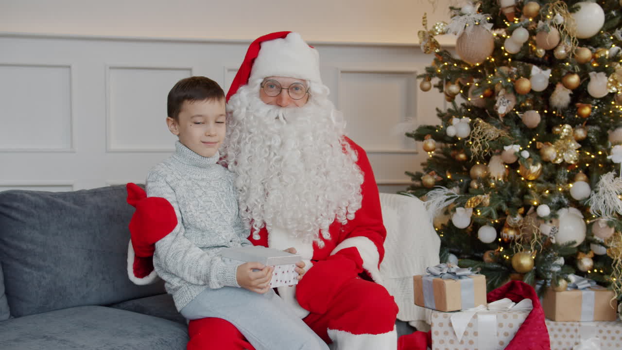 Babbo Natale con un bambino sul divano