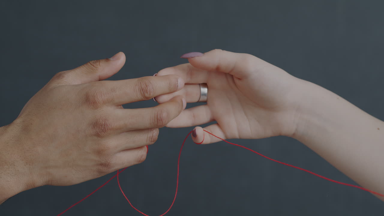 Hands Intertwined with Red String