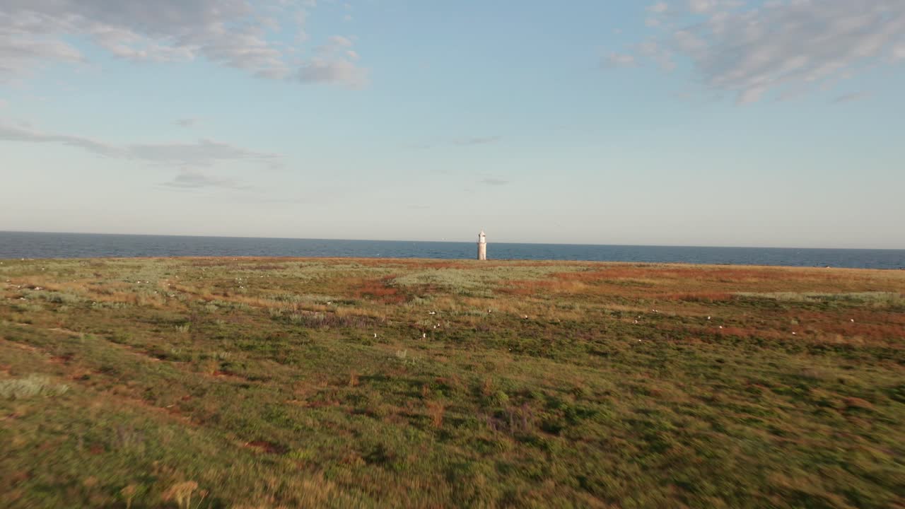 aproximación aérea al faro de la isla al atardecer
