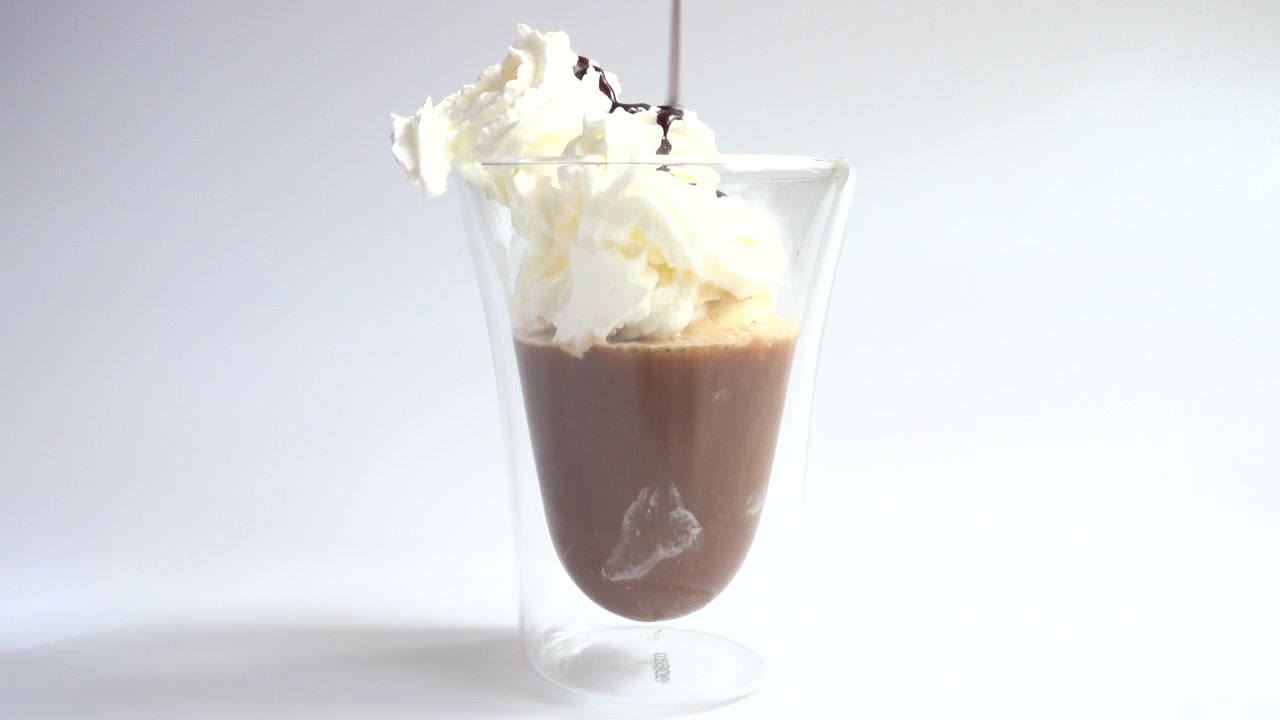 Preparación de café helado con helado, nata montada y sirope de chocolate