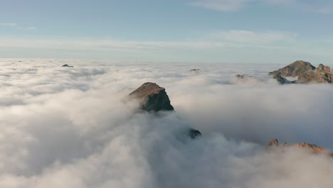 breathtaking view of mountain peak sticking out of clouds in madeira