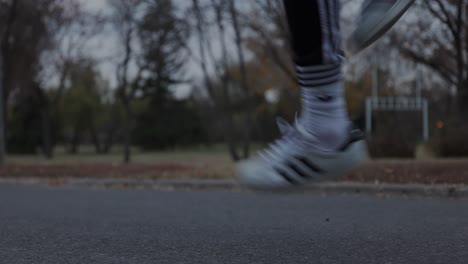 Vista-A-Nivel-Del-Suelo-De-Los-Pies-De-Un-Atleta-Masculino-Saltando-La-Cuerda-En-Un-Parque