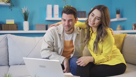 una joven pareja feliz chateando con sus padres en video chat en casa.