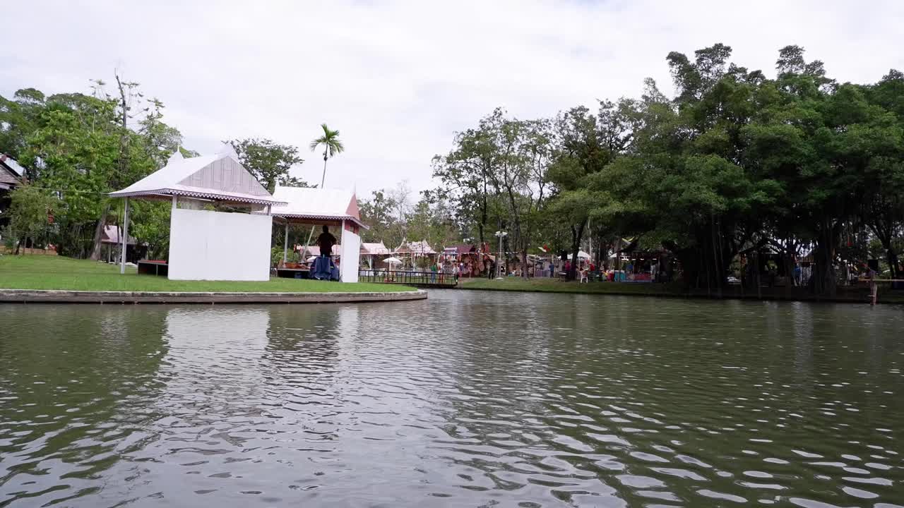 multitud junto al lago con exuberante vegetación.