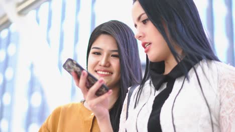 beautiful asia woman looking smartphone and talking with friend. concept of technology, communication, business, shopping online and fashion.