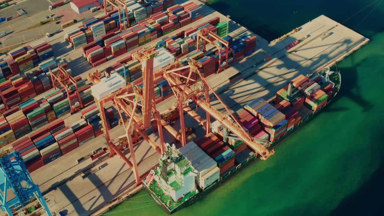Aerial view of containers loading and unloading to the ship in the sea port. Logistic and transportation of goods. Crisis and shortage of containers in the world