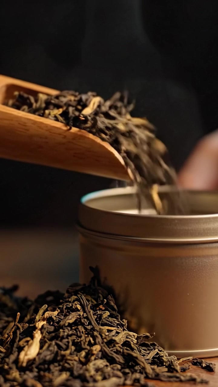 A Close-Up Look at Loose Leaf Tea Being Scooped from a Tin Container with a Wooden Spoon, Highlighting the Rich Textures and Aromas of the Tea Leaves