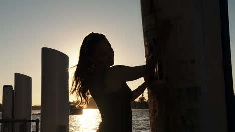 Foto-De-Silueta-Del-Cabello-De-Una-Bella-Dama-Al-Atardecer-Con-Agua-En-El-Fondo-Jugando-Con-El-Sol-Al-Atardecer