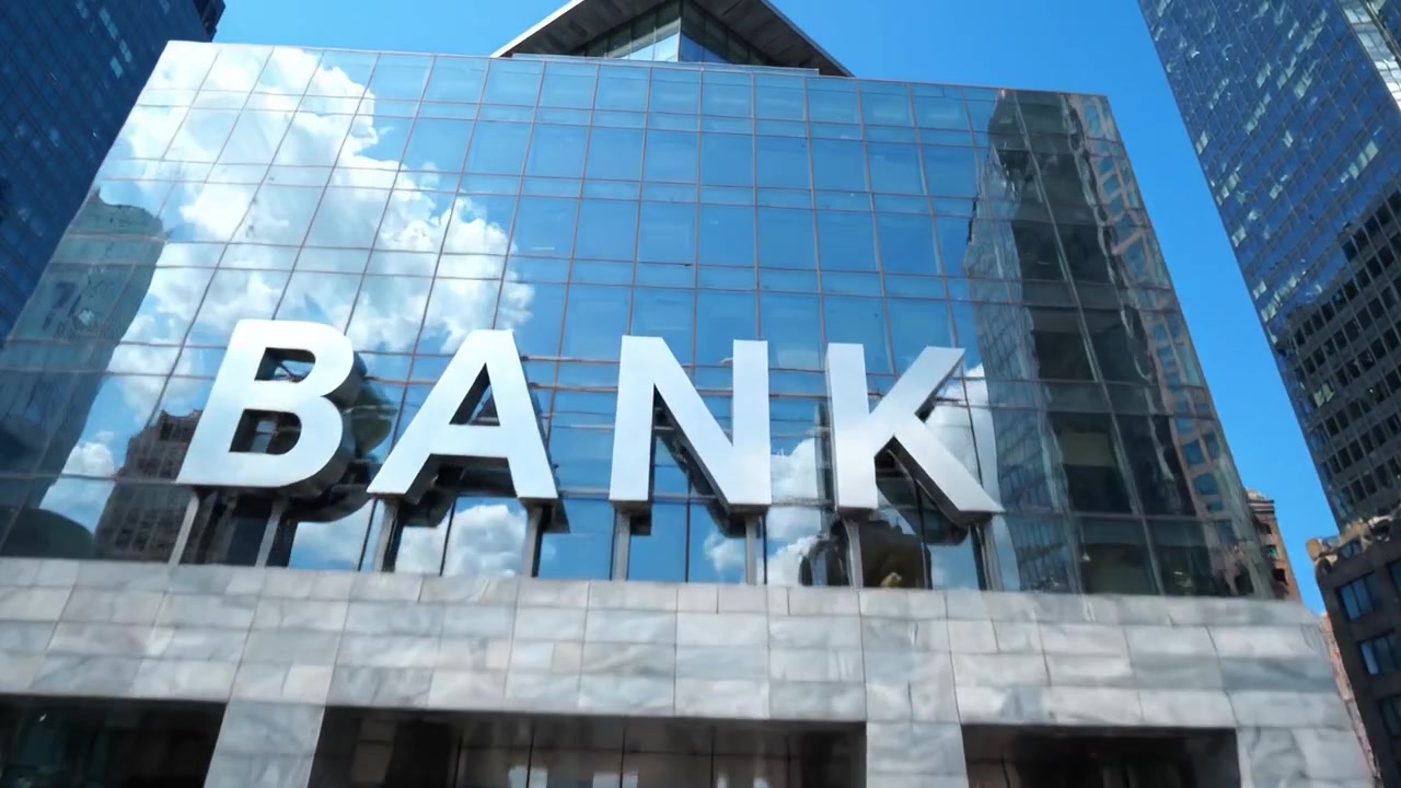 Um Edifício Bancário Moderno Refletido em um Céu Limpo, Exibindo Arquitetura de Vidro, Vida Urbana Vibrante e um Reflexo Mesclado das Estruturas Circundantes.
