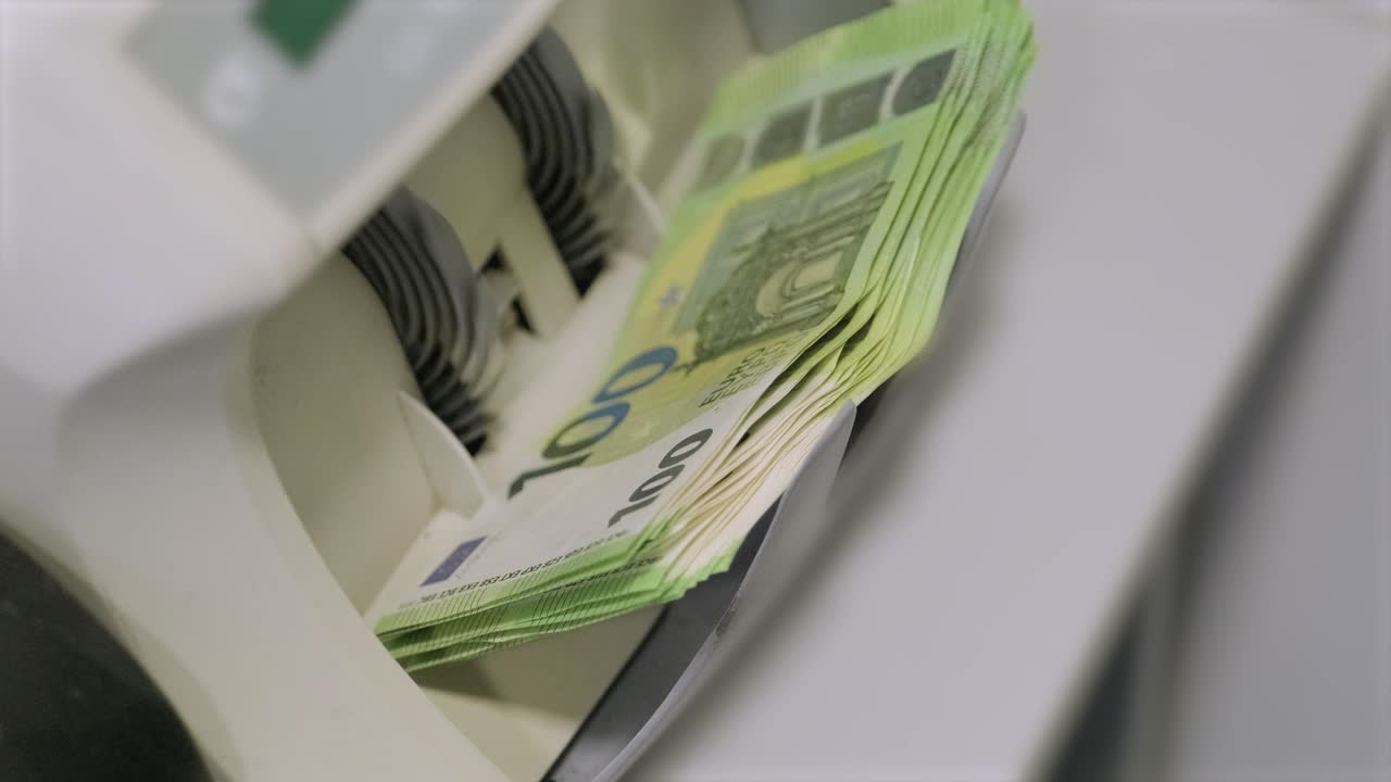 Die Geldzählmaschine zählt Dollarnoten. Tausend-Dollar-Scheine. Hundert-Dollar-Scheine.