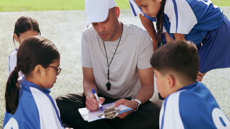 coach, clipboard and children on field for soccer