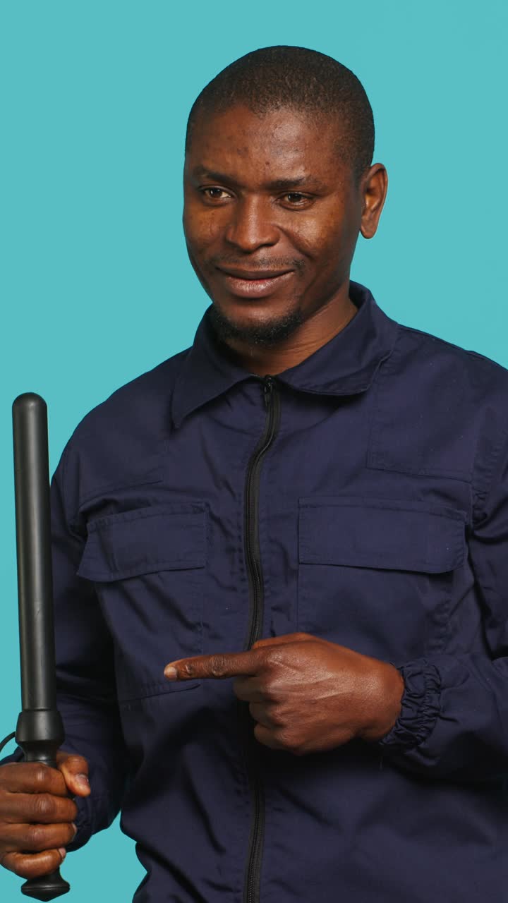 African American Man Holding Baton and Pointing on Blue Background