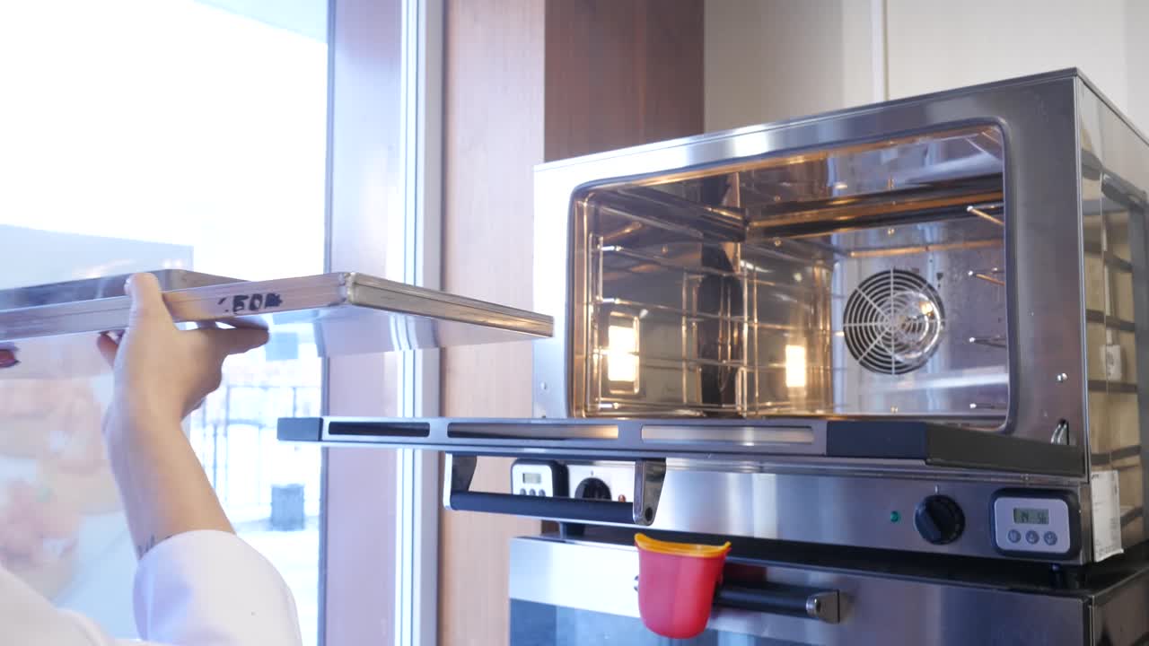 el chef está comprobando el horno.