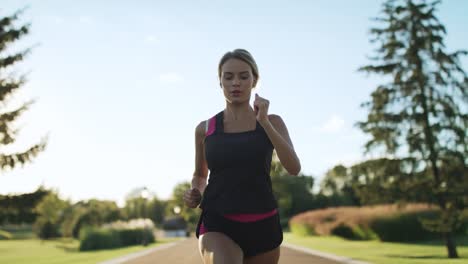athlete woman jogging in park. female runner breathing hard at outdoor training
