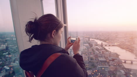 tourist taking photograph of sunset in london skyline  view from the shard