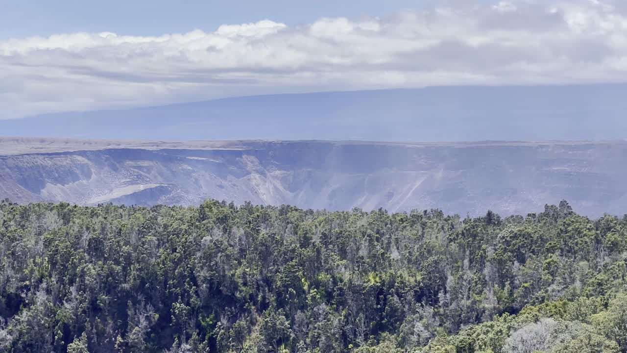 Cinematic long lens panning shot of the Kilauea Crater from an overlook on the Kilauea Iki trail in Hawai'i Volcanoes National Park