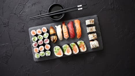 Sushi-rolls-set-with-salmon-and-tuna-fish-served-on-black-stone-board