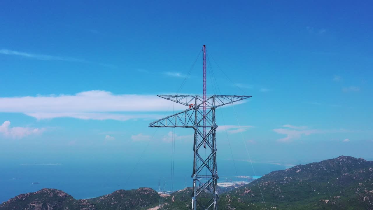 Droneoptagelse af højspændingsmaster med ledningspylon i bjergområde til distribution af elektricitet - Naturlandskab og industrielt koncept for bæredygtig udvikling.