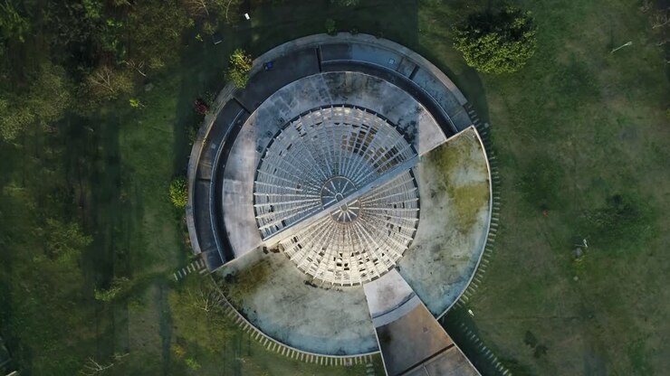 Drone shot on camera going up and spinning around orchidarium in public park full of lush vegetation, tranquility, nature, calm, peace, in 4K resolution