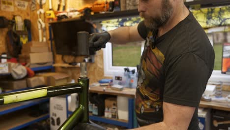 male bicycle mechanic releases forks with hammer