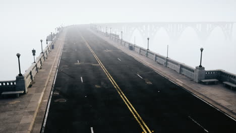 An-empty-illuminated-asphalt-road-in-a-thick-fog