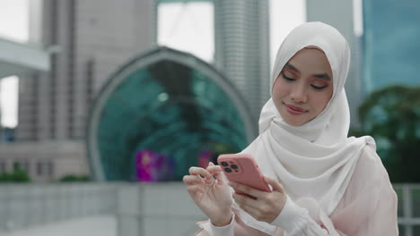 young muslim woman using smartphone in city