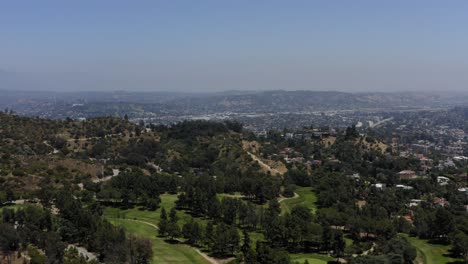 Aerial-shot-showcasing-some-various-homes-over-the-mountains-of-Los-Angeles-then-showing-the-mountains-themselves