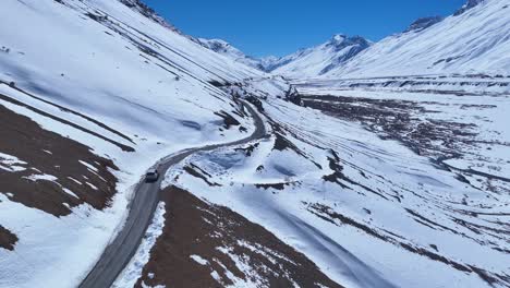 snowy mountain road with a car