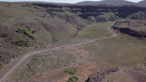 vista aérea: la furgoneta conduce por un camino sinuoso en las tierras de moses coulee