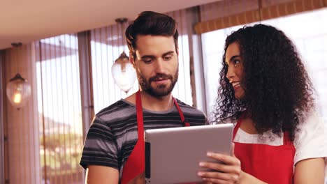 Smiling-waiter-and-waitress-using-digital-tablet