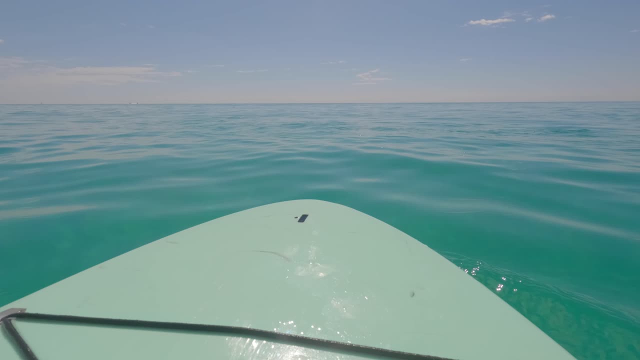 tabla de remo flotando frente a la costa de miramar beach, florida, en el golfo de méxico.