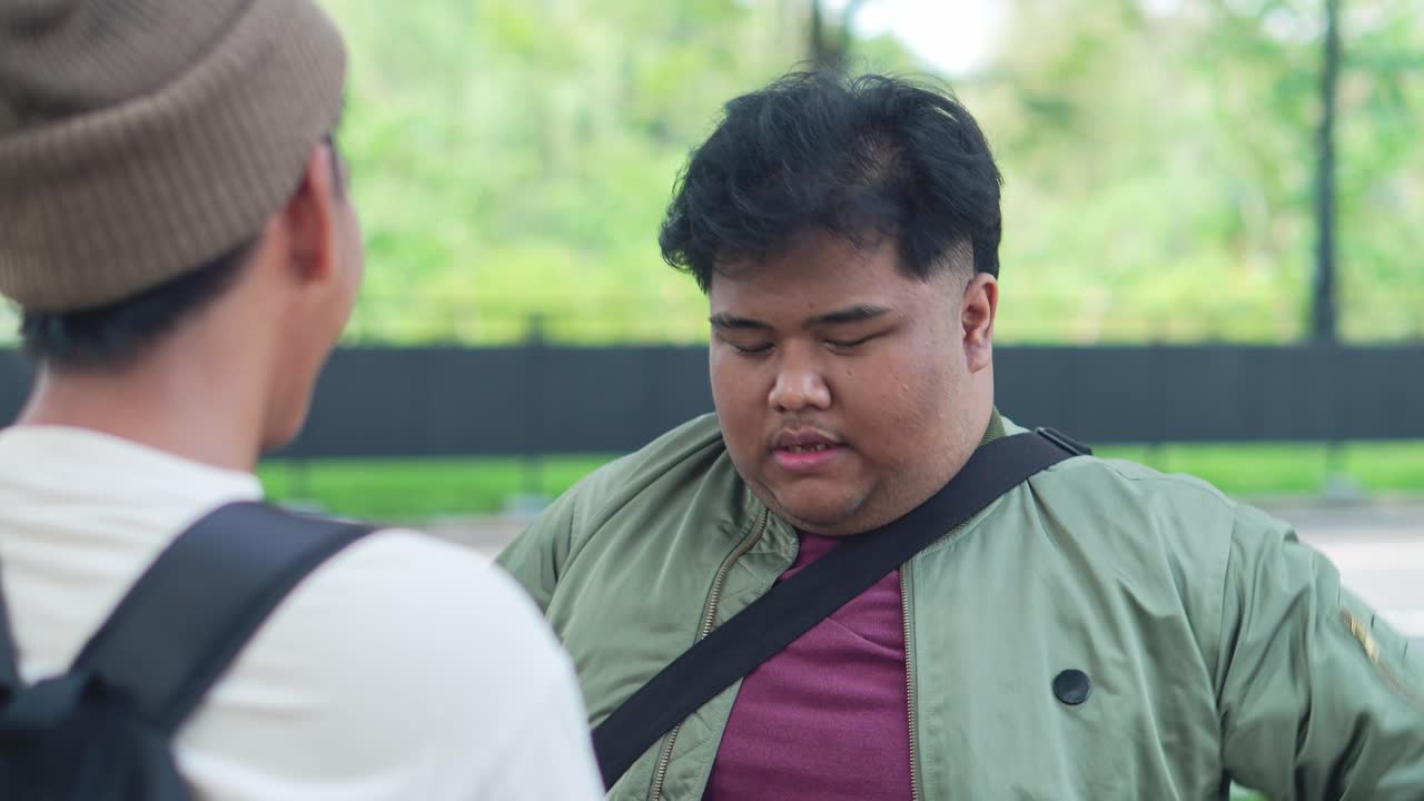 Two Asian College Students Talking At The Campus Park
