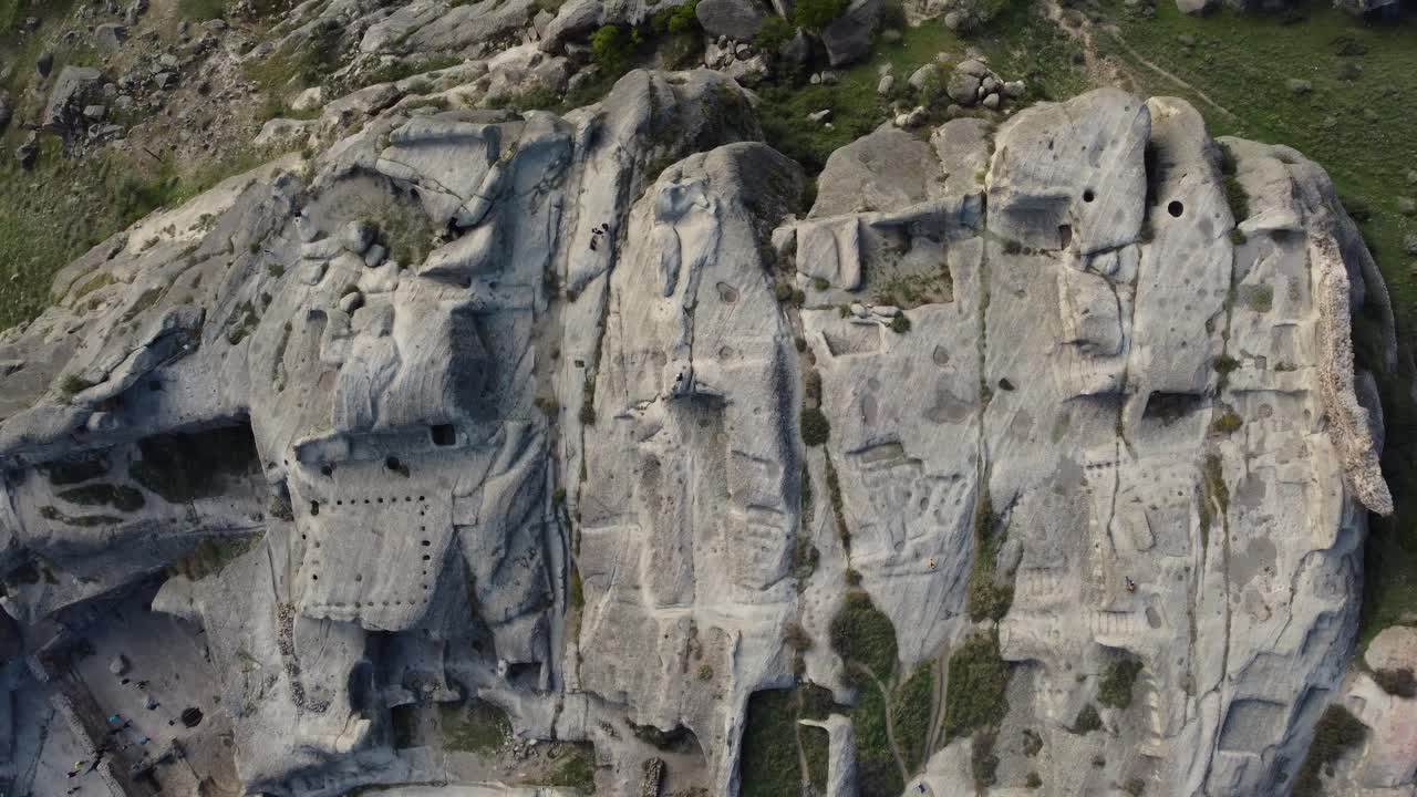 Wide panoramic of Uplistsikhe cave city surrounded by hills and valleys in Georgia
