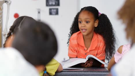 Front-view-of-African-American-schoolgirl-teaching-schoolkids-in-the-classroom-4k