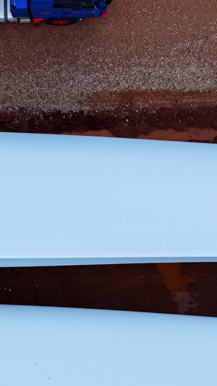 Vertical drone pan of large wind turbine blades at the Augstkalni wind farm in Smiltene, Latvia. Sustainable green energy infrastructure